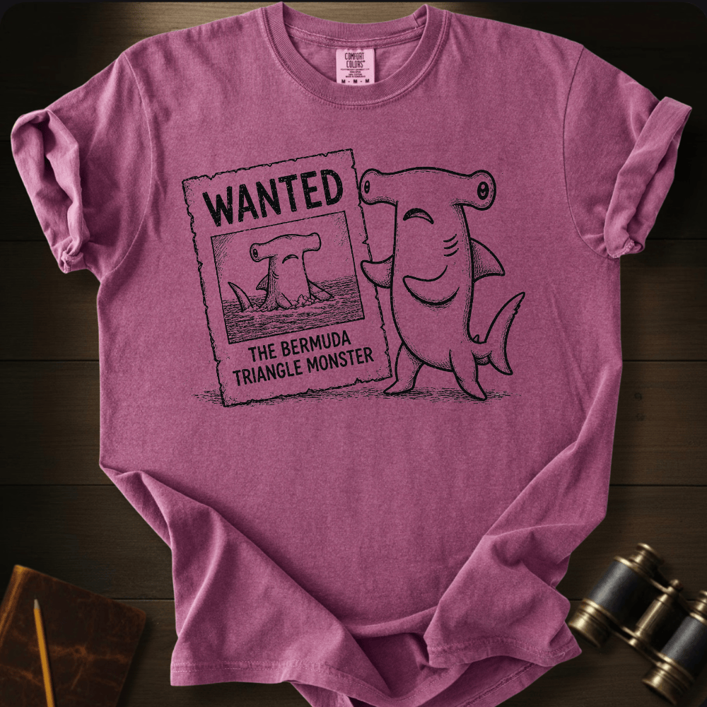 Berry Comfort Colors tee with a cartoon hammerhead shark holding a 'Wanted: The Bermuda Triangle Monster' poster.