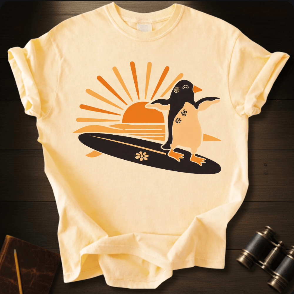 Full Sail Marine Sunset Surf penguin surfing graphic Comfort Colors t-shirt in ivory – cute penguin on surfboard with sunset design – front view