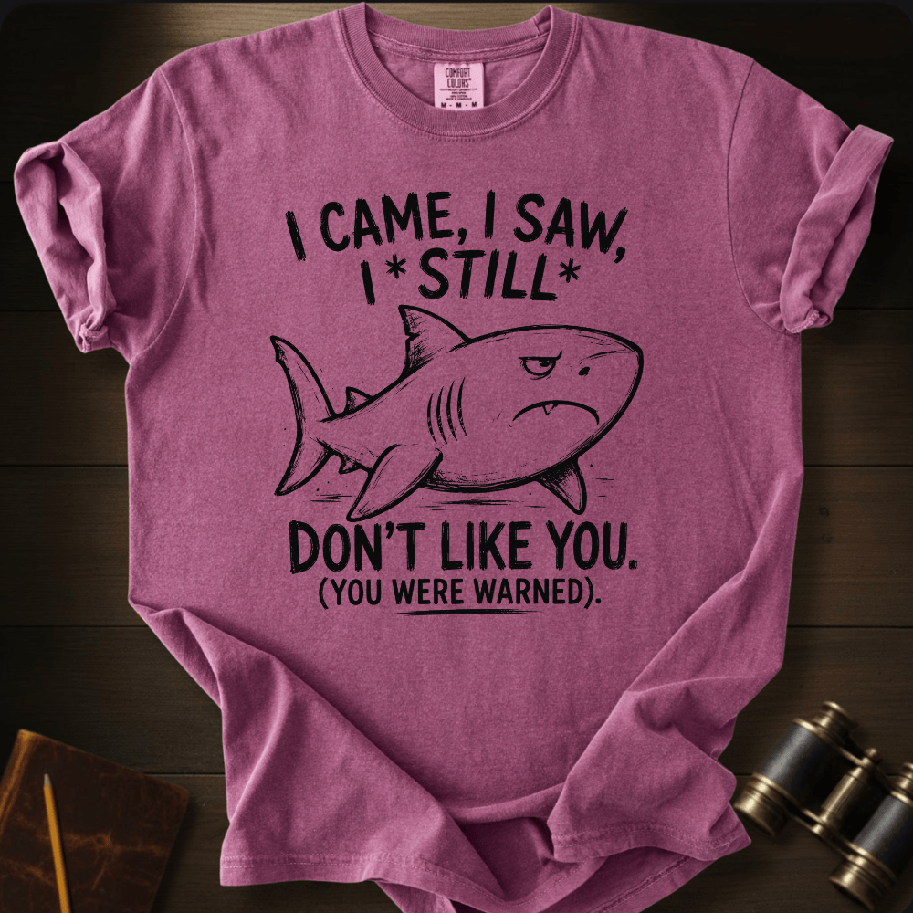A heathered mauve-purple short-sleeve t-shirt with a black graphic of a shark and the text 'I CAME, I SAW, I*STILL* DON'T LIKE YOU. (YOU WERE WARNED.