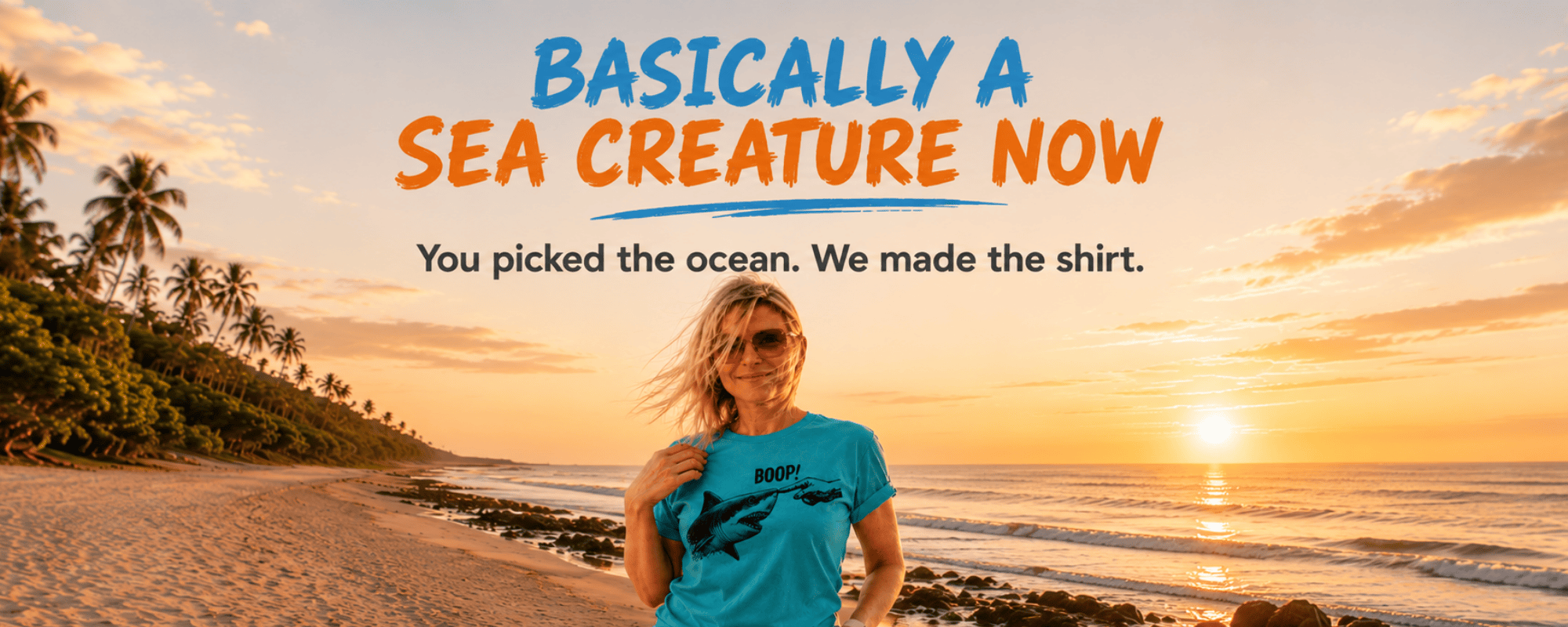 Woman wearing FullSailMarine's BOOP shark graphic tee on a Comfort Colors blue tee — sunset beach with palm trees.
